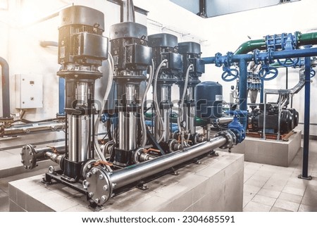 Industrial interior of water pump, valves, pressure gauges, motors inside engine room. Automatic control systems, Industry pumps in an technical room, urban modern powerful pipelines. Copy text space