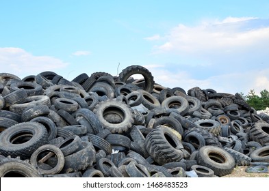 Industrial landfill for the processing of waste tires and rubber tyres. Pile of old tires and wheels for rubber recycling. Tyre dump