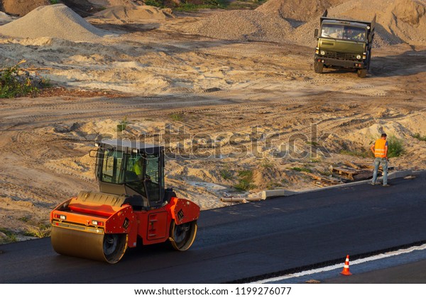 industrial\
landscape with rollers that rolls a new asphalt on the road. Repair\
work, complicated transport\
movement.