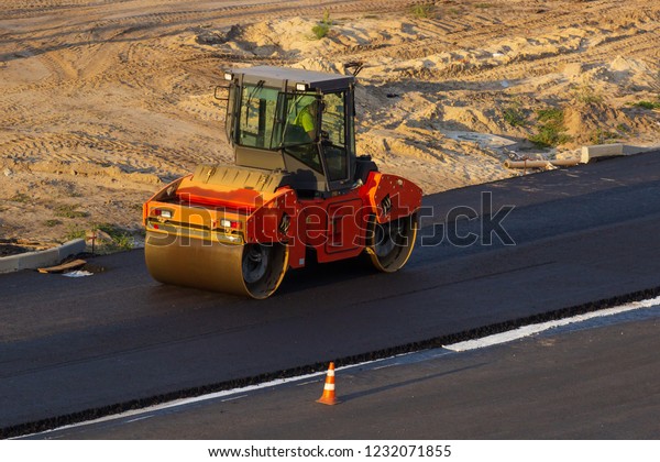 industrial\
landscape with rollers that rolls a new asphalt on the road. Repair\
work, complicated transport\
movement.