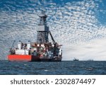 Industrial landscape with ships off the coast of Namibia in Walvis Bay. Offshore oil and gas drillship in the open sea with other cargo ships.