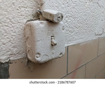 Industrial Light Switch And Receptacle With Padlock Painted Over With Cream Colored Paint.