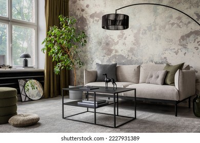 Industrial and loft living room interior with concrete wall, gray sofa, modern armchair, simple black coffee table, green pillows, curtain, books and personal accessories. Home decor. Template. 