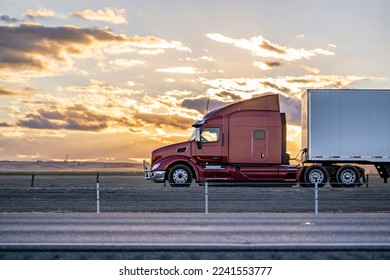 Industrial long hauler big rig burgundy semi truck tractor with chrome parts transporting commercial cargo in loaded dry van semi trailer running on the highway road at sunset time in California - Shutterstock ID 2241553777