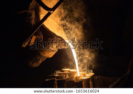 Industrial lost wax casting. The process of pouring for filling out ceramic shells with molten steel.
