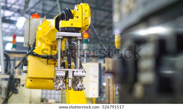 industrial machine and factory robot concept -\
Blurred of  factory robot arm with control box and copy space. Use\
for robot factory artwork\
concept