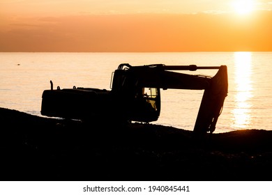 Industrial Machinery Working At Beach In Sunset