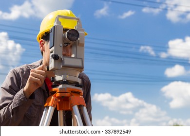 Industrial Man Engineer Surveyor Standing On Ground Working With Telescope Leveling Tools Survey For The Construction Of Buildings