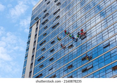 Industrial Mountaineering, Group Of Workers Cleaning Windows Service On High Rise Building. Work On The Heights