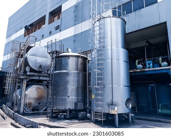 industrial oil tanks, and construction made of sturdy stainless steel with an industrial building background. - Powered by Shutterstock