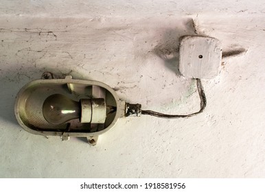 Industrial old ceiling lamp (storage or factory lamp) with vintage off bulb on dirty white wall in a warehouse, basement or attic - Powered by Shutterstock