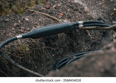 Industrial Optical Cable Connection, Y Split Of A Cable, Shielded In A Plastic Enclosure Seen Dug Up From The Ground Or Trench At A Construction Site.