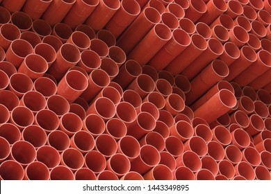 Industrial orange ppr tubes are neatly stacked, orange round tubular background material
