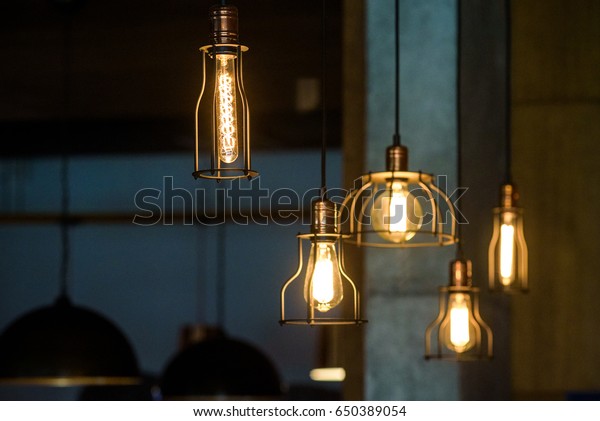Industrial pendant lamps against rough wall. Loft\
interior. Edison\
bulbs.