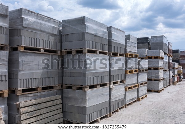 Industrial production of building cement pressed\
materials. High quality hollow concrete block or cement brick and\
paving stones. Finished products on pallets packed in film are\
waiting to be\
shipped.