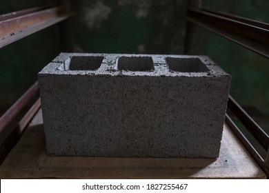 Industrial production of building materials from pressed cement mortar. High quality hollow concrete block or cement brick. Finished products stacked on pallets dry after the press.