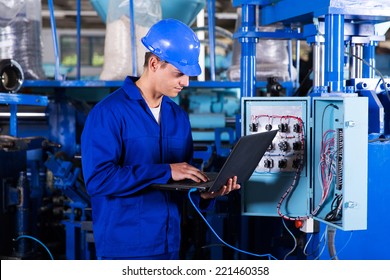 industrial programmer checking control box status with laptop computer - Powered by Shutterstock