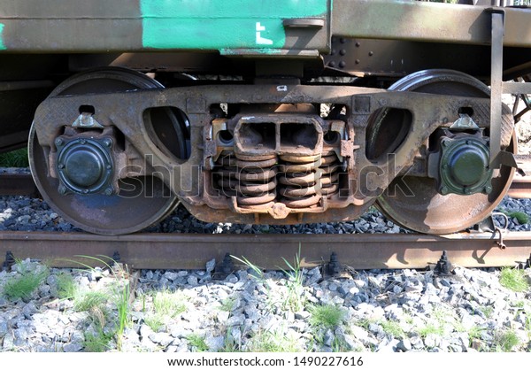 Industrial rail car wheels closeup. Laying\
the brake shoe under the  of a freight\
car.