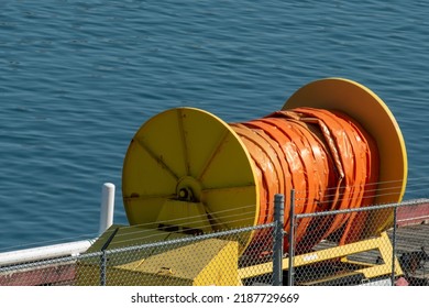 An industrial reel of orange oil sorbents spills containment boom absorbent material for environmental accidents and disasters at sea such as oil spills, chemicals, poison, waste, and toxic materials.