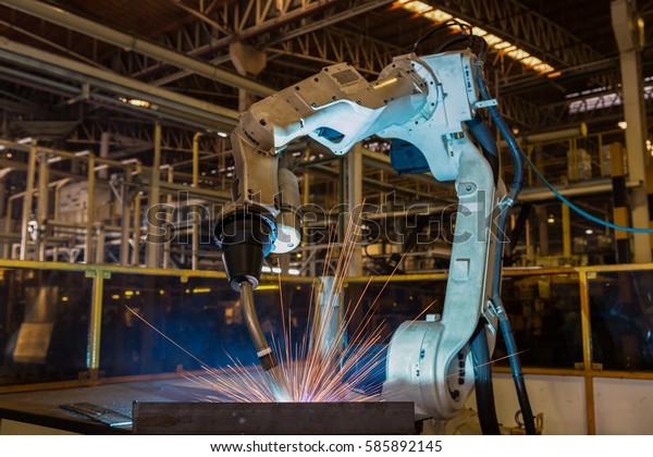 Industrial\
robot is welding assembly  part in car\
factory
