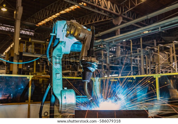 Industrial robot\
welding metal part in car\
factory