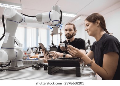 Industrial Robotics program university students learning education mechanical assembly with Robot Universal Training Platform robot arm simulation model in engineering lab classroom. - Powered by Shutterstock