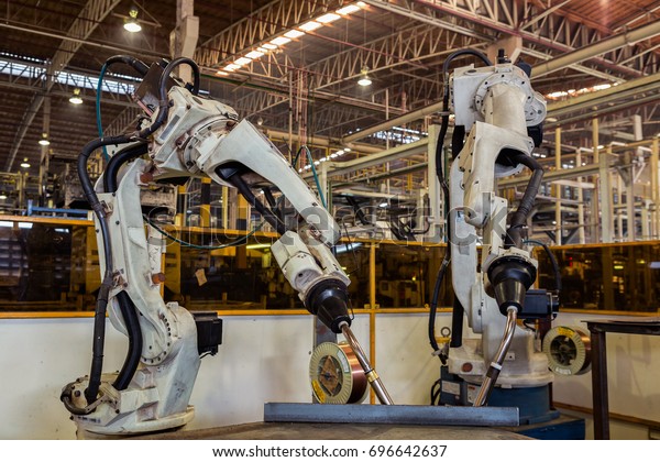 Industrial robots are welding test run program in\
car factory