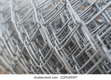 Industrial Rolls Of Aluminum Chain Link Fencing.close Up Steel Wire Net Texture For Background.Rolls Of  Steel Wire Mesh For Use Of Fencing.Close Up Of Wire Mesh Fence In Roll