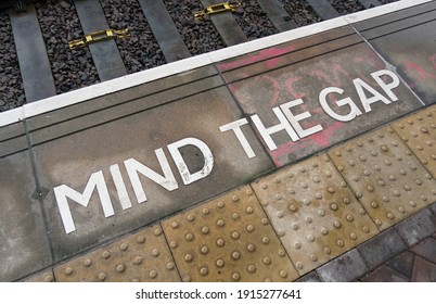 An Industrial Rustic Weather Gritty Urban Textured Railway London Tube Mind The Gap Floor Font. City Street Texture And Decaying Weather City Environment. Grit And Rough Textured Cement Flooring.