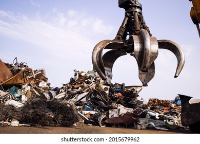Industrial scrap metal recycling and crane lifting parts in junk yard.