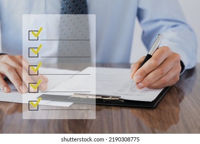 An industrial or shipping inspector auditor supervisor is writing a pen to check the inventory of tasks that need to be done and has a checklist icon - Shutterstock ID 2190308775