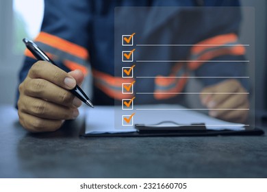 industrial or shipping inspector auditor supervisor reflective jacket is writing a pen on clipboard to check the inventory of tasks that need to be done and has a checklist icon. To do list concept - Shutterstock ID 2321660705