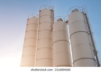 Industrial silos for loose material storing. The silos of the factory in which the raw materials, cement, sand and gravel are present. batching plant. Industrial architecture. - Shutterstock ID 2116004360