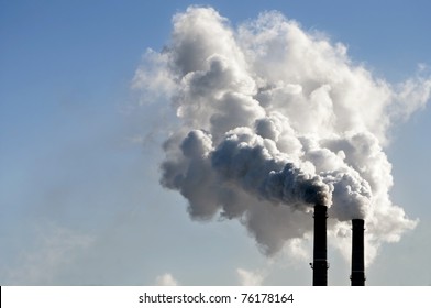 industrial smoke from chimney on blue sky
