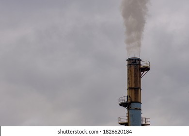 An Industrial Smokestack Billows A Stream Of Greenhouse Gasses Into The Atmosphere.