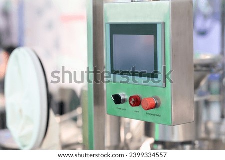 Industrial stainless steel control console with touch screen in pharmaceutical factory. Selective focus.