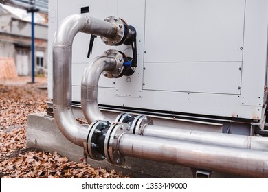 Industrial stainless steel pipes connected to the commercial cooling unit for the HVAC systems