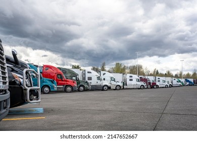 Industrial standard different bigs rigs semi trucks tractors with loaded semi trailers standing for break and truck driver rest on the wide truck stop parking lot according to the traffic schedule - Shutterstock ID 2147652667
