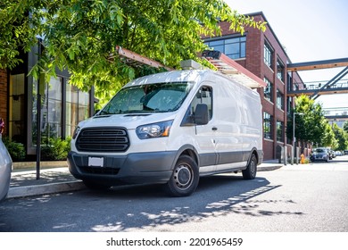 Industrial Standard For Local Deliveries And Short Haul Freights Or Small Business Services Compact White Mini Van Standing On The Urban City Street With Apartment Buildings