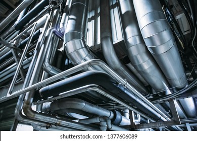 Industrial steel pipes or tubes of air ventilation system as abstract industry equipment background in blue tones