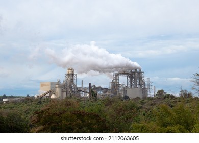 Industrial Steel Plant Emitting Steam From Its Chimney Over An Cerrado Forest