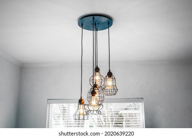 Industrial style metal and glass hanging pendant light in eat in kitchen in a small home. - Powered by Shutterstock