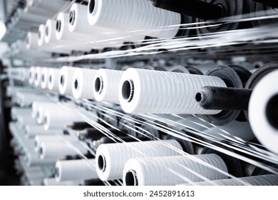 Industrial textile machine with thread spool. - Powered by Shutterstock