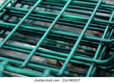 Industrial texture background: green metal iron grating, turquoise grid. Steel grate in perspective. Garden fence, lattice