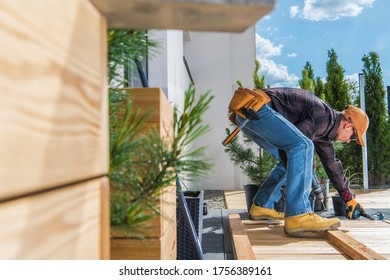 Industrial Theme. Home And Garden. Wooden Porch Building By Caucasian Men In His 30s During Sunny Summer Day. Small Backyard Project.