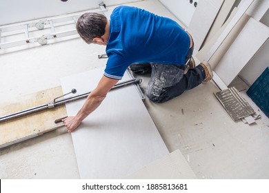 Industrial tiler builder worker working with floor tile cutting equipment