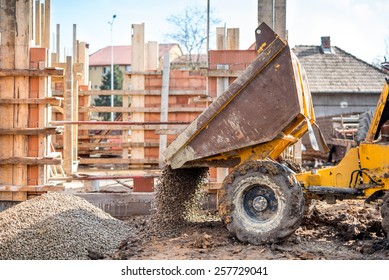 Industrial Truck Loader Excavating Gravel And Construction Aggregates. Construction Site With Dumper Truck And Materials