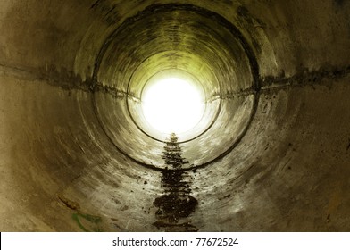 An Industrial Tunnel Leading Into The Light