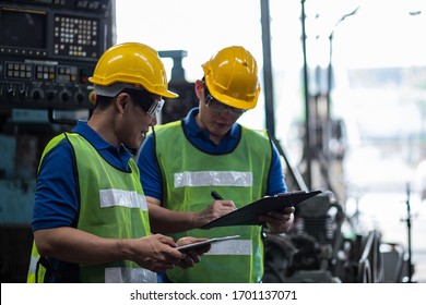 Industrial two men engineers in a factory checking documents - Powered by Shutterstock