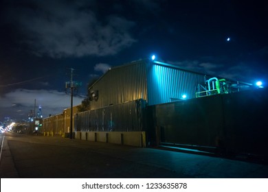 Industrial urban street city night scene with vintage factory warehouses and the moon